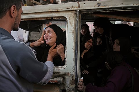 Palestinians hold onto an aid truck returning to Gaza City from the northern Gaza Strip on Tuesday, July 22, 2025.