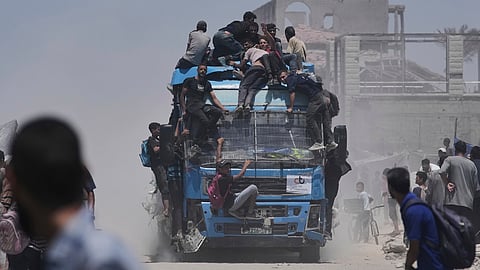 Palestinians hold onto an aid truck returning to Gaza City from the northern Gaza Strip on Tuesday, July 22, 2025.