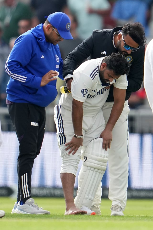 Rishabh Pant getting inspected after getting hit in the foot before being carried off the field in Manchester. 