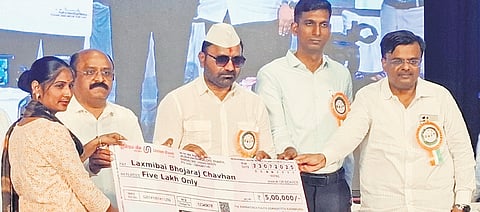 Labour Minister Santosh Lad distributes compensation cheque to a relative of a labourer in Vijayapura on Wednesday.
