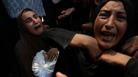 Maysara Adwan, left, mourns as she holds the body of her 11-year-old son, Qais,