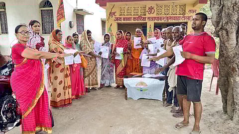 Voters show the enumeration forms given by a Booth Level Officer (BLO) during the ongoing Special Intensive Revision of electoral rolls in Vaishali district, Bihar