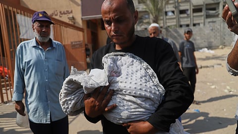Ahmed Abu Halib carries the body of his 5-month-old baby, Zainab, who died from malnutrition-related causes, according to the family and the hospital, during her funeral outside the Nasser Hospital, in Khan Younis, Gaza Strip, Saturday, July 26, 2025.