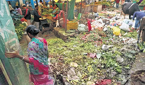 A woman struggles to make her way through a road blocked by dumped vegetable waste at Monda Market in Hyderabad | Sri Loganathan Velmurugan