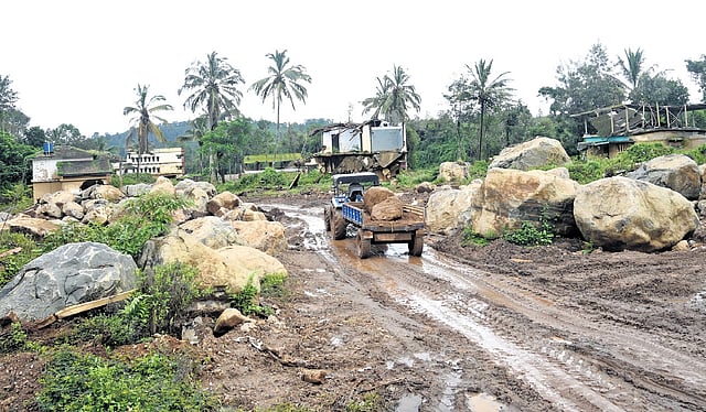 the rocks and debris from the landslide being cleared from the Chooralmala-Padavettikunnu Road