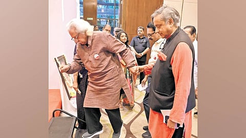 Congress MP Shashi Tharoor helps filmmaker Adoor Gopalakrishnan onto the stage at P Kesavadev Award ceremony in Thiruvananthapuram on Sunday. 