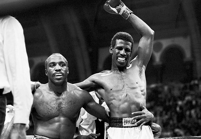 Michael Spinks raises his hand in victory as loser Dwight Braxton holds on to him in Atlantic City, N.J., March 18, 1983. 
