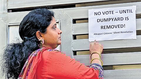 An aspiring candidate points to a notice on the dumpyard issue in the 9th division of Karimnagar municipality.