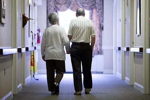 An elderly couple walks down a hallway in Easton, Pa., on Nov. 6, 2015. 