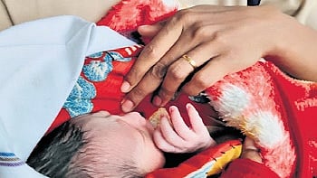 An RPF personnel keeps the newborn warm at Sir M Visvesvaraya Terminal 
on Thursday