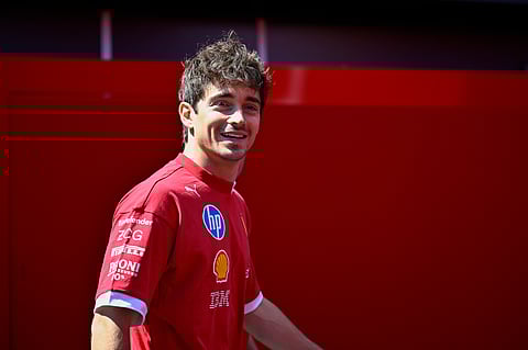 Ferrari driver Charles Leclerc of Monaco smiles in the paddock at the Hungaroring racetrack.