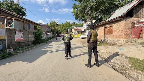 Security personnel stand guard amid an ongoing encounter between security forces and terrorists in a forest area at Akhal, in Kulgam district, Jammu and Kashmir, Sunday, Aug. 3.