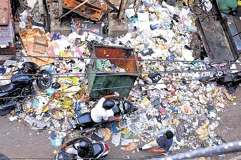 People walk through uncleared garbage at Richie street. Shop owners complain that it has not been removed for nearly a week