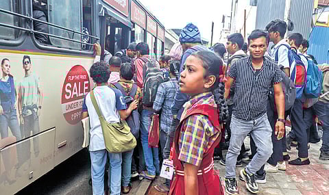 A girl waits to board a bus as commuters jostle to enter one of the few BMTC buses plying during the state-wide strike in Bengaluru on Tuesday 