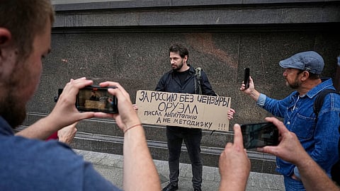 An activist holds a sign reading, "For Russia without censorship. Orwell wrote a dystopia, not an instruction manual,” referring to author George Orwell during a protest in front of the State Duma, the lower house of the Russian parliament, in Moscow, Russia, Tuesday, July 22, 2025, prior to lawmakers approving a measure that punishes online searches for information that is deemed "extremist".