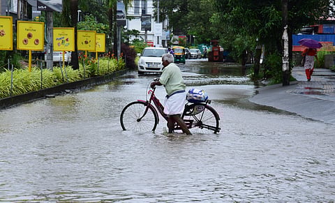 An old man crossing the waterlogged road at Stadium Link road in Kochi.
