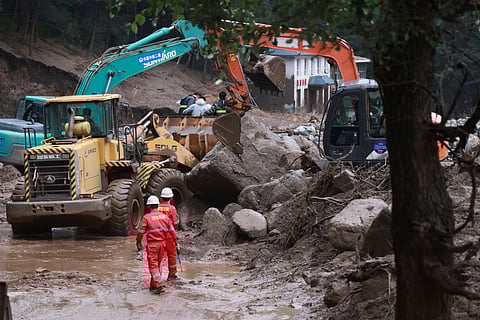In this photo released by Xinhua News Agency, Rescuers work to restore a road damaged by mountain torrents following a heavy downpour, in Yuzhong County of northwest China's Gansu Province, Friday, Aug. 8, 2025.