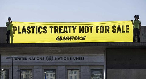 Greenpeace activists display a placard during an action against the oil producers in the margin of the Plastics Treaty negotiations, at the entrance of the European headquarters of the United Nations in Geneva, Switzerland, Thursday, August 7, 2025. 