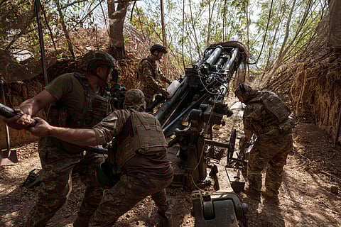 Ukrainian servicemen of the 148th artillery brigade set up a M777 howitzer before firing towards Russian positions at the frontline in Zaporizhzhia region, Ukraine, on Thursday, Aug. 7, 2025.