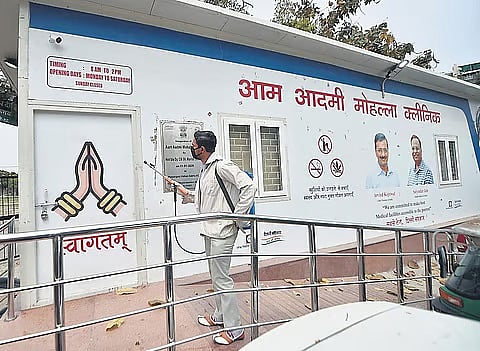 People take rest outside a Mohalla Clinic, in New Delhi.