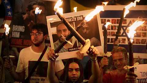 Demonstrators light torches during a protest demanding the immediate release of all hostages from Hamas captivity in the Gaza Strip and calling for an end to the war, outside the prime minister's office in Jerusalem, Thursday, Aug. 7, 2025.