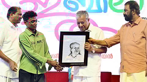 A tribal student from Idukki gifting Chief Minister Pinarayi Vijayan his portrait at the golden jubilee celebration of ST Development Department 