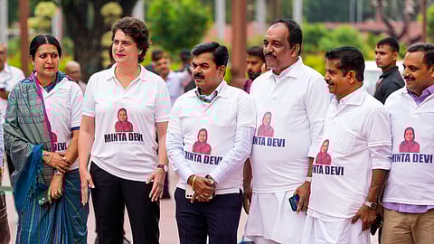 Congress MP Priyanka Gandhi Vadra and other INDIA bloc members seen wearing T-shirts featuring the name Minta Devi, a voter allegedly listed as 124 years old in the Election Commission's voter list, during their protest over the issues of 'poll fraud' and Special Intensive Revision of electoral rolls, at the Monsoon session of Parliament, in New Delhi, Tuesday, Aug. 12, 2025. 