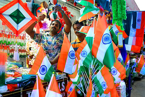 A shopkeeper displaying National flag ahead of Independence Day celebrations at Sikkim. 