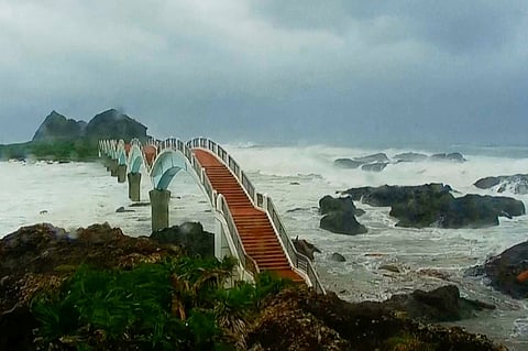 In this image made from video released by Taitung County Government, strong waves and heavy rain pound the Sansiiantai tourist spot on Aug. 13, 2025, as Typhoon Podul reaches Taitung, eastern Taiwan.