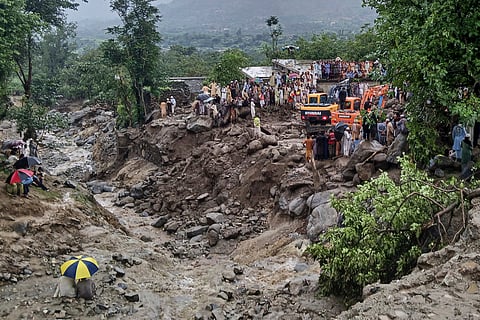 Rescuers and local residents use heavy machinery to recover bodies during a rescue operation at the site of a massive cloudburst that led to flash flooding, in Salarzai, in Bajaur district, in northwestern Pakistan. 