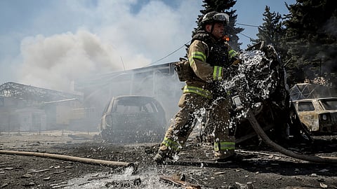 In this photo provided by Ukraine's 24th Mechanised Brigade press service, a firefighter puts out a fire after a Russian drone hit a market in the town of Druzhkivka, Donetsk region, Ukraine, Saturday, Aug. 2, 2025.
