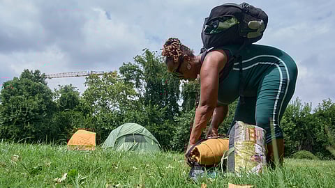 Ms Jay, of Washington, who lost her job and is living what she calls her "Girl Scout life" while saving money by urban camping and looking for work while homeless, packs up her tent and belongings in a small park by Georgetown, Wednesday, Aug. 13, 2025, in Washington.