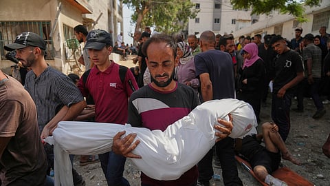 A Palestinian man carries the body of his 7-year-old nephew, Alaa Al-Toum, who, according to the family, was killed in an Israeli army airstrike last night, during his funeral at Shifa Hospital in Gaza City, Saturday, Aug. 16, 2025