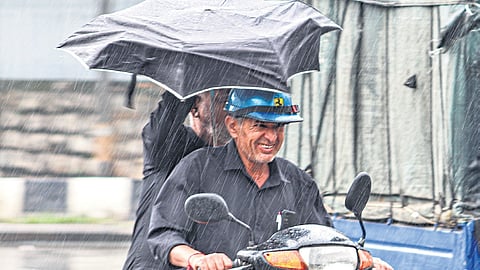 A motorist struggles to ride amid rain near Shivajinagar. The city saw continuous drizzle throughout the day spoiling the Sunday plans of many citizens.