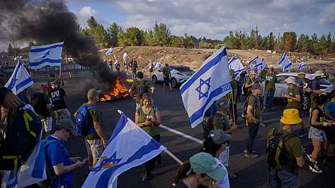 Demonstrators block a road during a protest demanding the immediate release of hostages held by Hamas and calling for the Israeli government to reverse its decision to take over Gaza City and other areas in the Gaza Strip, near Jerusalem.