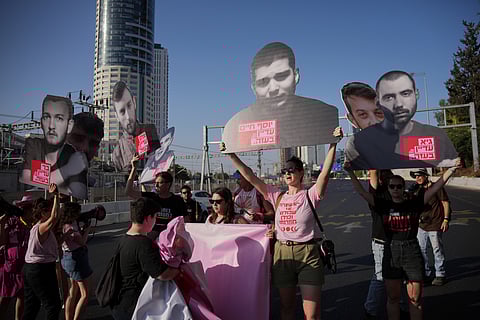 Demonstrators block a road during a protest demanding the immediate release of hostages held by Hamas and calling for the Israeli government to reverse its decision to take over Gaza City and other areas in the Gaza Strip, in Tel Aviv, Israel, Tuesday, Aug. 19, 2025.