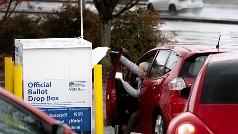 FILE - A voter drops off their ballot at a dropbox on Election Day, Nov. 5, 2024, in Portland, 