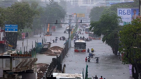 People wade through a waist-deep flooded road following heavy rainfall at Kurla West in Mumbai on Tuesday, Aug. 19, 2025.