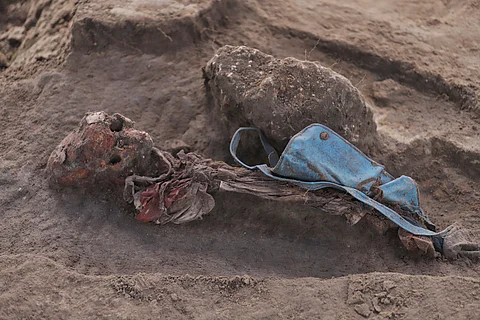 An exhumed human skeleton is seen with a school bag at the site of a mass grave in Chemmani, Sri Lanka, June 28, 2025.