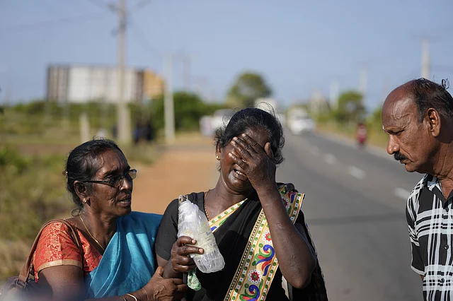 Senthilvel Sothiladchumi, an ethnic Sri Lankan Tamil, center, whose son went missing during the Sri Lankan civil war, cries as she leaves the site of a mass grave where authorities exhibited unearthed belongings in an effort to secure the identities of the victims, in Chemmani, Sri Lanka, Aug. 5, 2025.