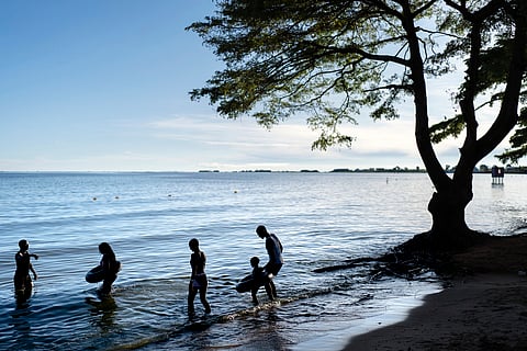 People wade into the waters of Lake Victoria, the world's second-largest freshwater lake, Nov. 25, 2024, in Entebbe, Uganda. 