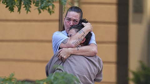 Crystina Page, back, hugs a well-wisher outside the El Paso County Courthouse after a judge ruled against accepting a plea deal in the case of a funeral home owner who stored roughly 189 decomposing bodies in a building Friday, August 22, 2025, in Colorado Springs, Colo.