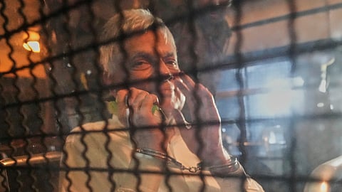 Former Sri Lankan President Ranil Wickremesinghe shows his handcuffs inside a bus taking him from court to a prison in Colombo, Sri Lanka, Friday, Aug. 22, 2025.