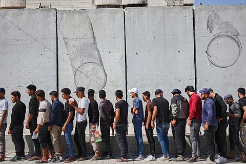 Young Kurdish men line up to sign up to join Syrian government's General Security forces at a police station in Afrin, Syria, an area in the country's north from which Kurds were forcibly displaced years ago, Thursday Aug. 21, 2025. 