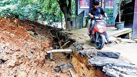 A biker tries to navigate the road that was dug up in Malleswaram.