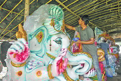 An artist giving final touches to a Ganesh idol in Vijayawada 