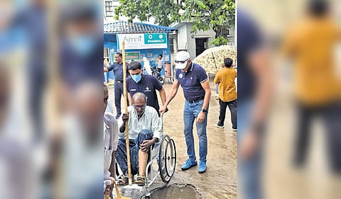 Health workers take an elderly patient to MGM Hospital in a wheelchair.