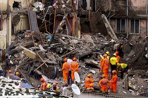 Rescue operation underway after a four-storey unauthorised building collapsed onto adjacent vacant chawl, at Virar, in Palghar district, Thursday. 