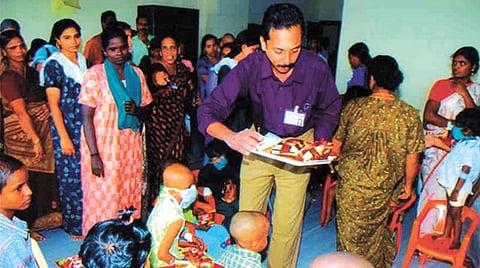 An Asraya volunteer distributes gifts to children