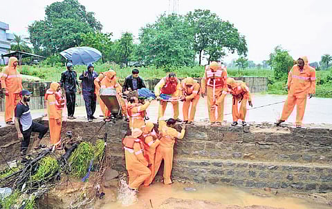 NDRF personnel carry a pregnant woman on a stretcher to an ambulance in Wadi village in Haveli Ghanpur mandal 